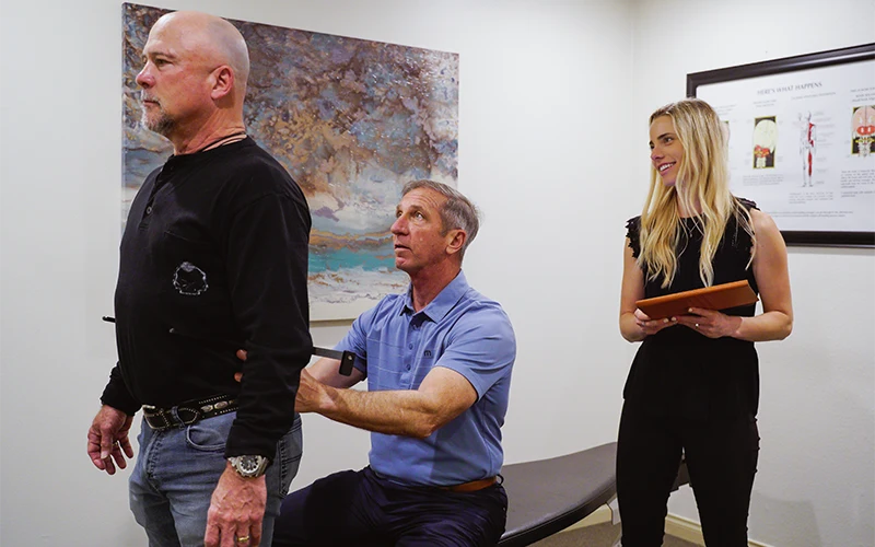 Chiropractors Dan Spinato And Chloé Lightner Examining A Patient